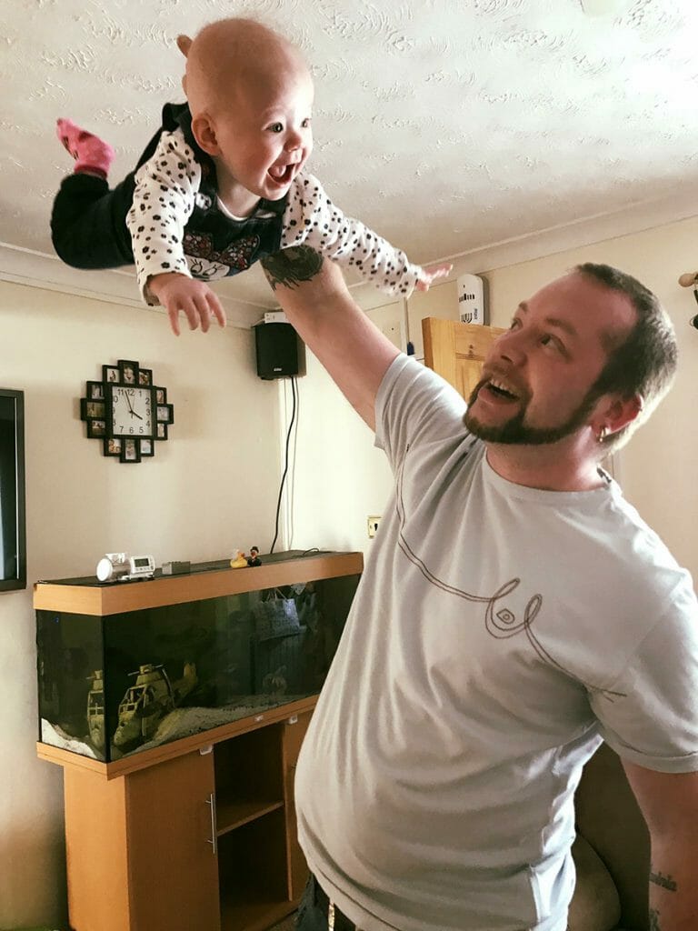 CHECT photo - Steve Crosbie throwing his daughter Lavinia up into the air, she is laughing