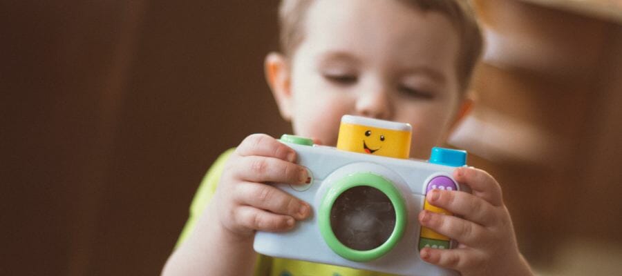 Photo of a little boy playing with a toy camera