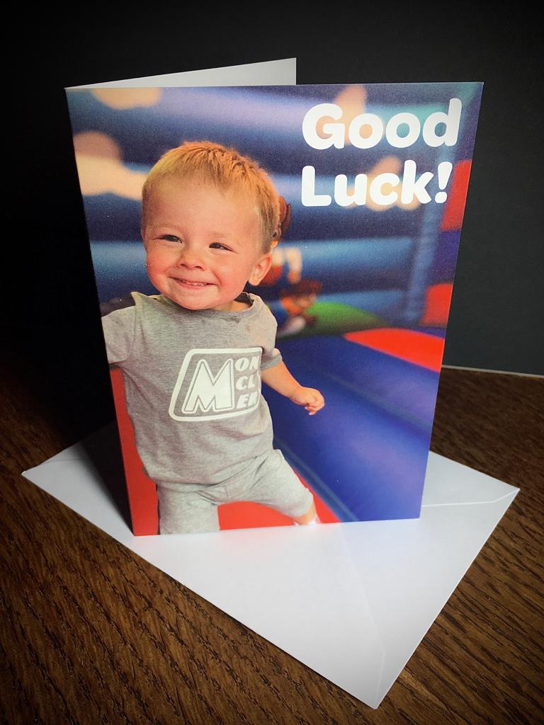 A photo of our printed CHECT good luck cards. Harris is at the front of the image smiling on a bouncy castle.