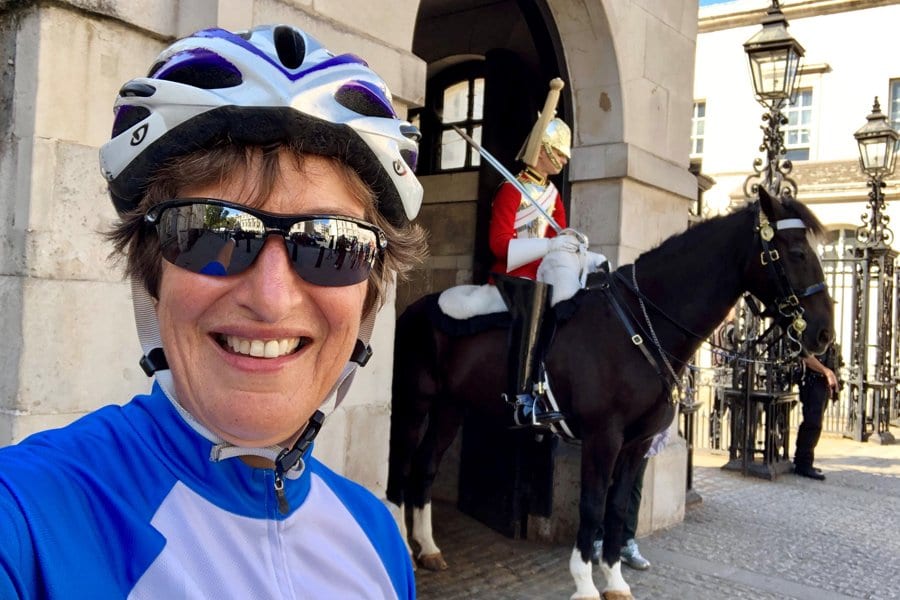 A lovely female cyclist doing the London to Paris posing in front of the Queen's Guard
