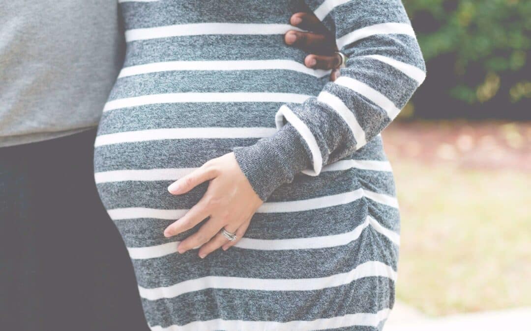 A pregnant lady holding her bump.