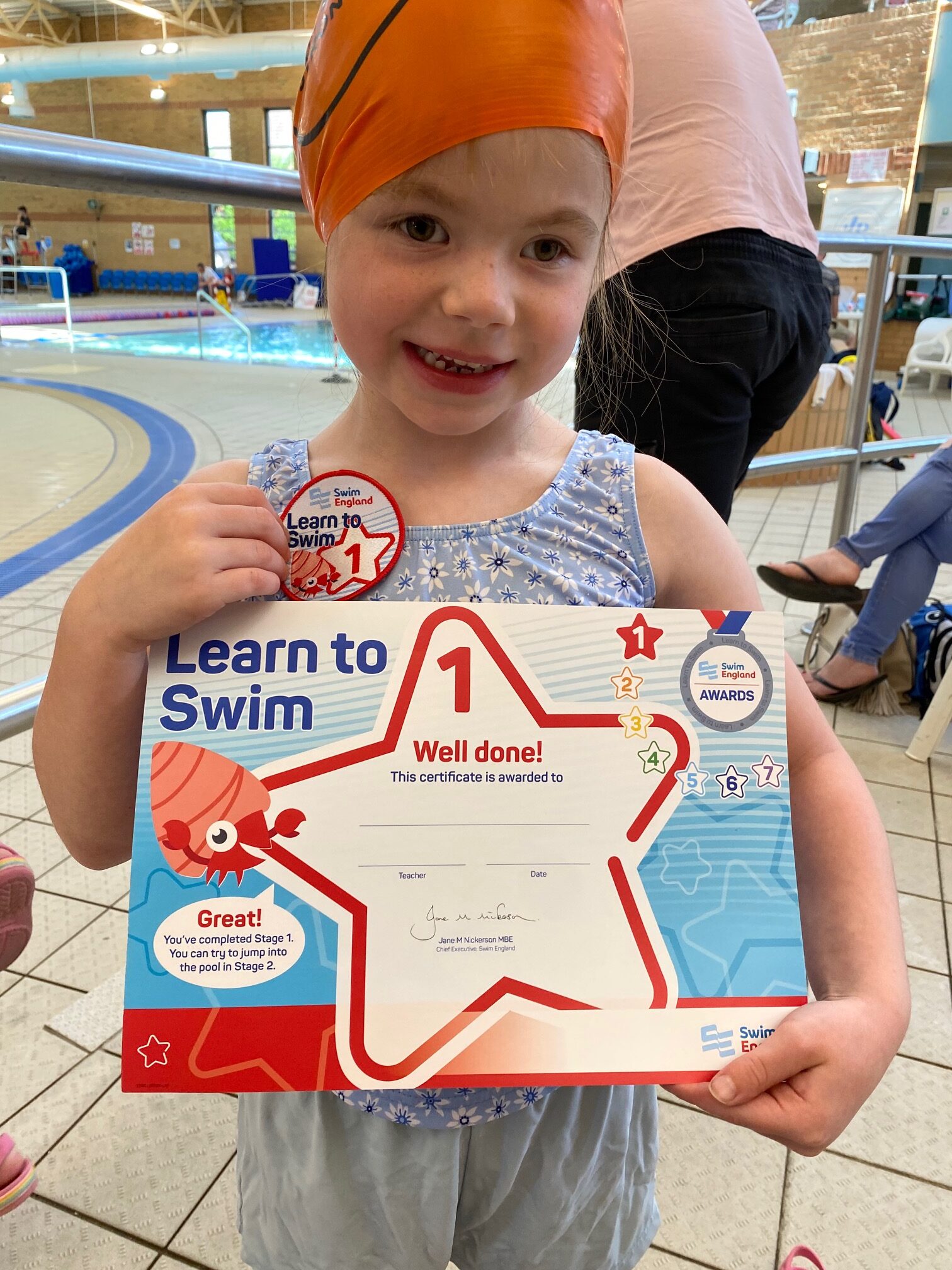 Lavinia holding up her swimming certificate