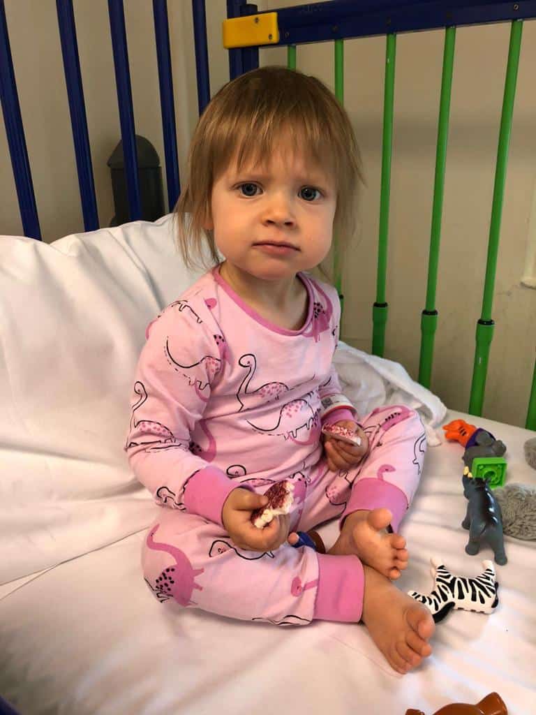 Isla in a hospital bed during treatment for  retinoblastoma - eye cancer