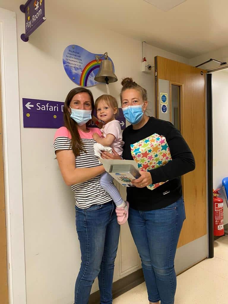 Isla and her parents ringing the bell  after being treated for retinoblastoma - eye cancer