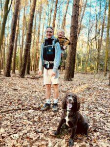 Ollie is pictured in the woods with his child and dog