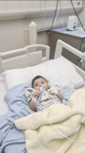 Shuhd in a hospital bed as a  baby