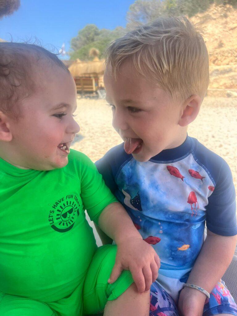 Kooper sticking out his tongue with his brother at the beach