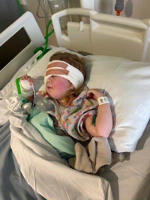 Jessy in hospital lying down, with a bandage on