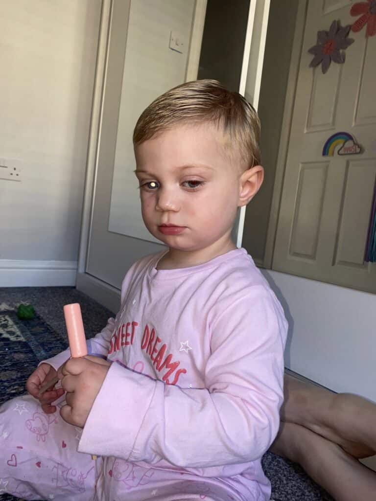 Raye has a white glow in one eye as she sits inside