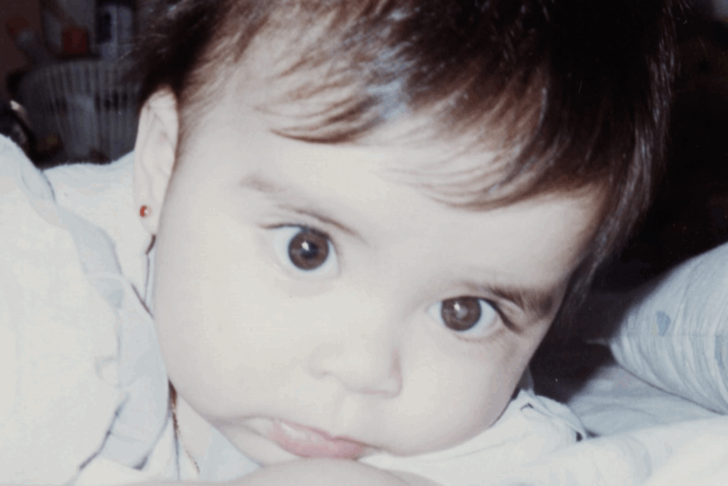 A close up of Hannah as. baby. She has a glow in one eye.